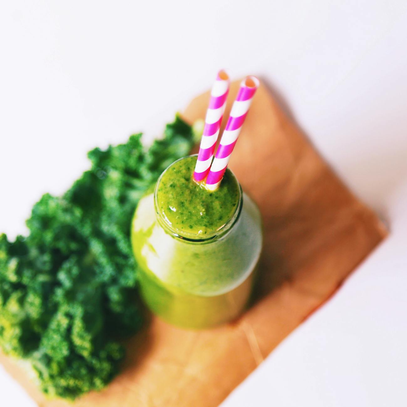 La imagen captura un batido de col Kale, una fuente rica en nutrientes y vitaminas. El Kale, también conocido como col rizada, es un vegetal de hojas verdes que ofrece una gran cantidad de beneficios para la salud. Algunos de los nutrientes presentes en el Kale incluyen:

Vitamina K: Importante para la coagulación sanguínea y la salud ósea.
Vitamina C: Un antioxidante que fortalece el sistema inmunológico.
Calcio: Beneficioso para los huesos y los dientes.
Ácido fólico: Esencial para el desarrollo celular y la salud del corazón.
El mantener una dieta equilibrada que incluya alimentos como el Kale nos ayuda a mantener nuestros niveles de ácido fólico y a promover una buena salud en general.
